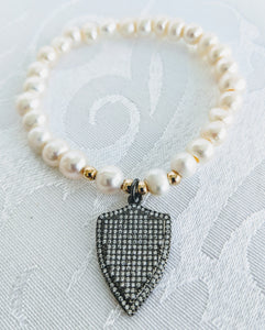 Pearl with gunmetal shield charm